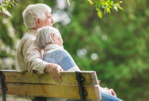 Elderly couple resting on a bench in the park