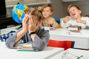 couple students bullying and suppress the guy sitting on the floor. Concept discrimination, racism and negative communication in school and society. Situations in school corridor