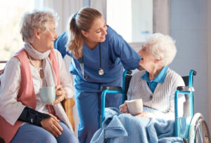 Nursing home, care and nurse with senior women doing healthcare checkup, examination or consultation. Medical, conversation and elderly woman in wheelchair consulting a doctor at retirement facility.