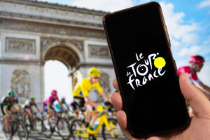 le tour de france bicycle race logo inside a smartphone with a bicycle competition at background
