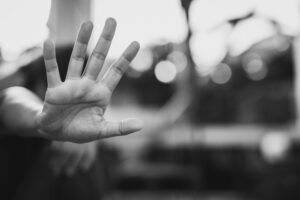 Stop harassment and abuse in relationship, a serious young asian woman standing with outstretched hand showing stop.