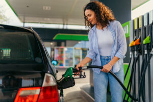 A student puts fuel in his car before leaving home for college