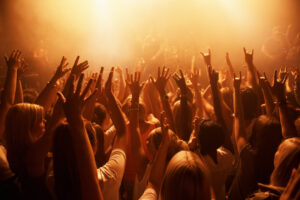 Music, concert and crowd of people dancing for performance with lighting equipment at party. Event, entertainment and group of fans or audience at festival, disco or rave with energy for song.