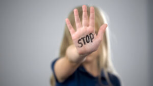Little girl showing stop sign, child abuse issue, cruelty in fam