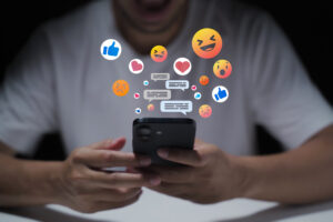 A man&rsquo;s hand is using a laptop or smartphone to chat on social media; communication concept, social networking, contact, online.